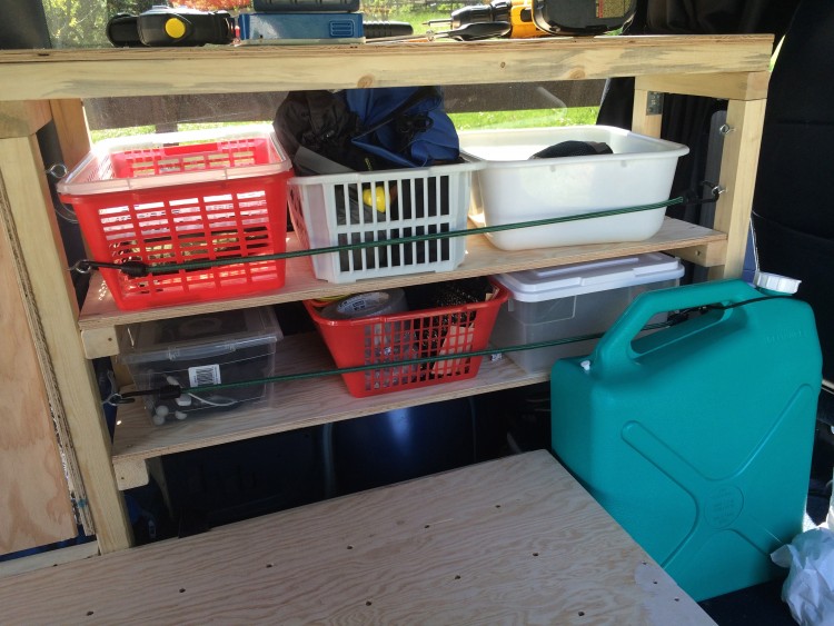 Containers kept in place on shelf using bungie cords